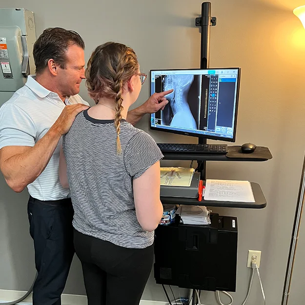 Pain Relief Evaluation - Cincinnati Ohio Chiropractor Dr. Baker reviewing a spinal X-ray with a patient